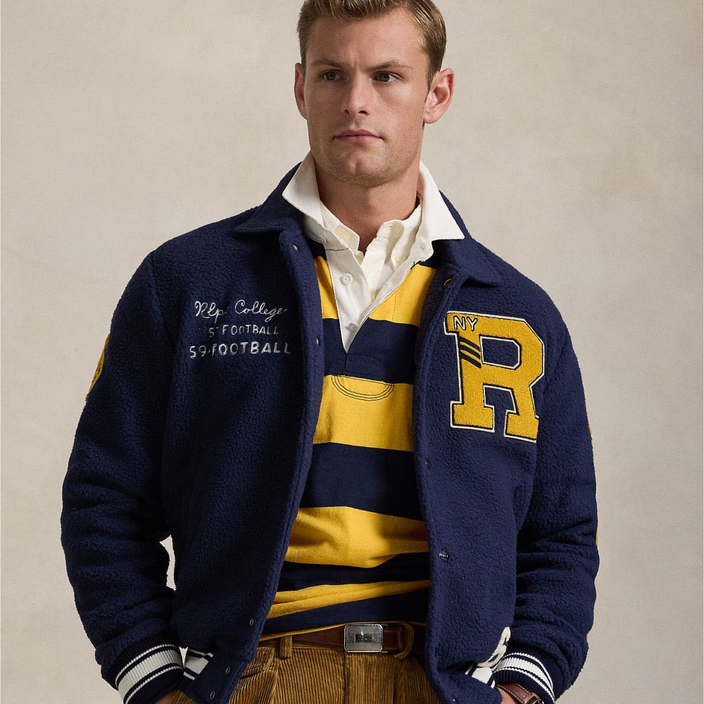 Crafted with curly pile fleece, this layer draws inspiration from classic letterman jackets, incorporating signature and varsity-inspired graphics.