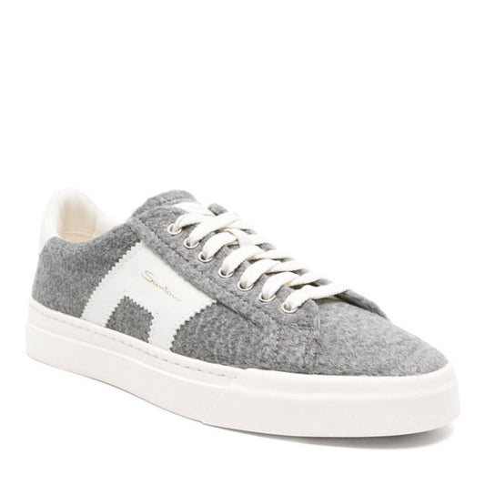 Santoni’s Double Buckle sneakers are named after the signature contrasting appliqué that decorates the sidewall. This pair is crafted from grey felt with leather panels and grounded atop a flat rubber sole.